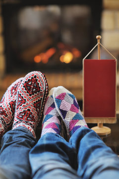 Young romantic couple relaxing in front of fireplace at home