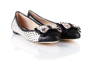 Female flat ballet shoes patterned with black polka dots