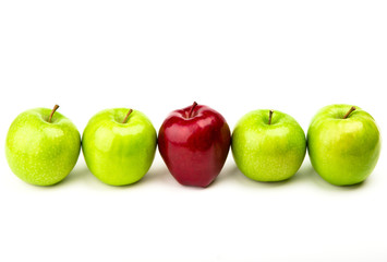 Red apple among green apples isolated on a white