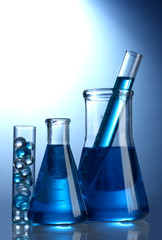 Test-tubes with blue liquid on blue background