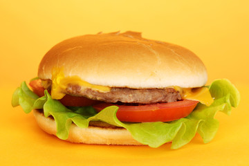 Tasty cheeseburger on yellow background