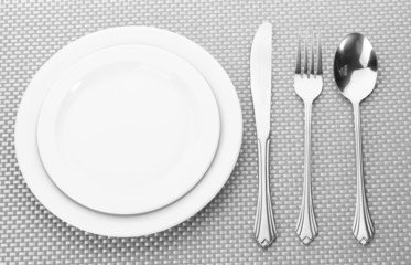 White empty plates with fork, spoon and knife