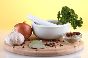 White mortar and pestle with spice on yellow background