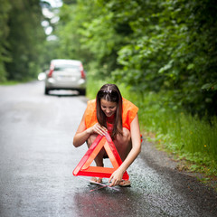 Young female driver after her car has broken down