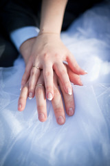 Hands newlyweds on a white dress