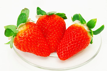 Fresh red strawberries on transparent plate