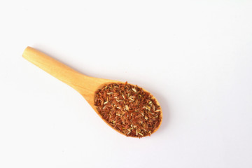 Close-up of a wooden spoon with red rice.