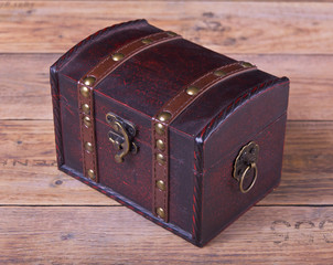 Schatztruhe geschlossen auf Holz Hintergrund