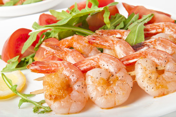 Fresh grilled shrimps with lemon on white plate