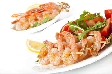 Fresh grilled shrimps with lemon on white plate