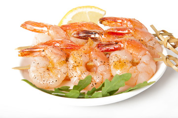Fresh grilled shrimps with lemon on white plate