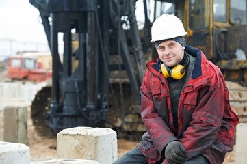 builder in dirty workwear at construction site