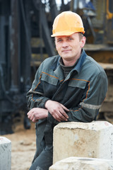 builder in dirty workwear at construction site