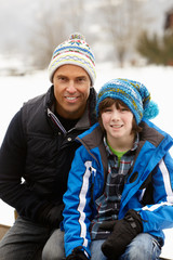 Portrait Of Father And Son Wearing Winter Clothes In Snowy Lands