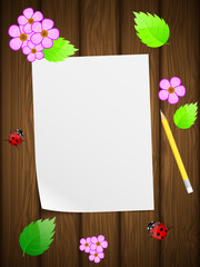 Blank paper on wooden background with flowers and ladybird.