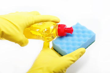 Hands in rubber gloves with a bottle of detergent and sponge on