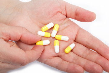 Pills in woman hand isolated on white background