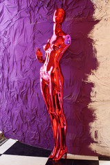 red mannequin at mauve wall