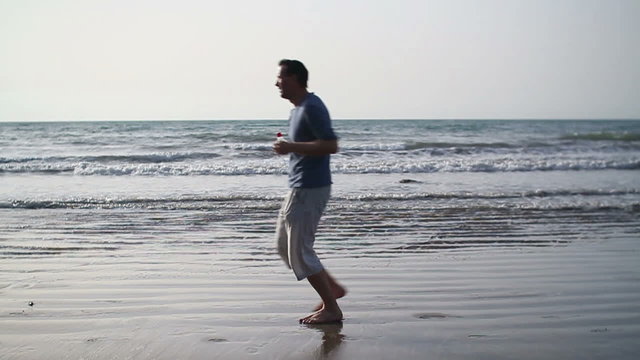 Young sport couple jogging on the beach, slow motion
