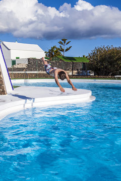 boy  jumping in the blue pool