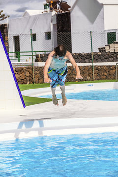 boy  jumping in the blue pool