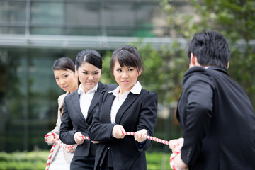 Business people having a tug of war fight.