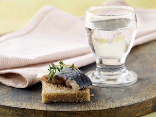 piece of herring on rye bread on a wooden board