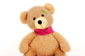 Teddybär mit einem Pflaster am Kopf