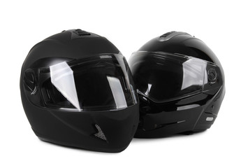 two black motorcycle helmets isolated