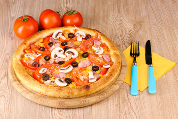 Aromatic pizza with vegetables on wooden background