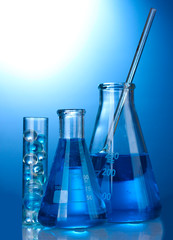 Test-tubes with blue liquid on blue background