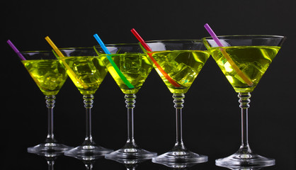 Yellow cocktail in martini glasses isolated on black