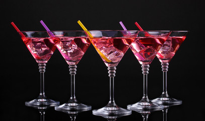 Red cocktail in martini glasses isolated on black