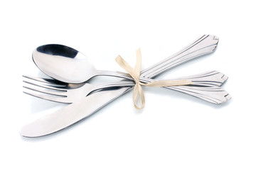 Silver fork, spoon and knife tied with ribbon isolated on white