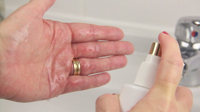 Female spraying toner on to hand from sprayer.