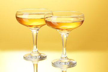 glasses of champagne on yellow background