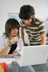 Students using a laptop computer in a classroom