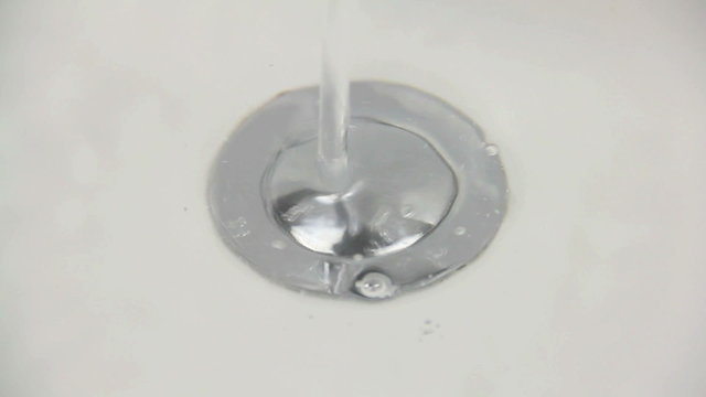 Water pouring into sink then releasing the plug.
