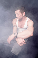 Ein Mann sitzt Gedanken verloren im Nebel