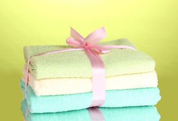 Obraz na płótnie Canvas Colorful towels with ribbon on green background
