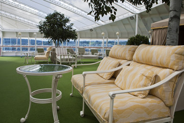 Sunbeds and sofa on open deck spa onboard of cruise ship