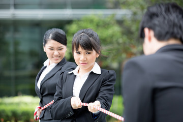 Business people having a tug of war fight.