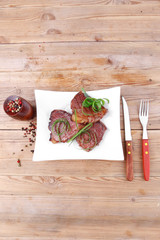 roasted beef meat on plate over wood