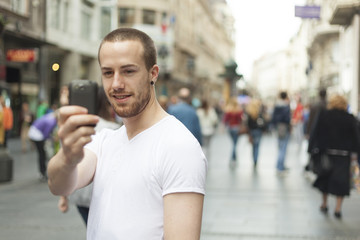 Guy with smartphone take photo on street