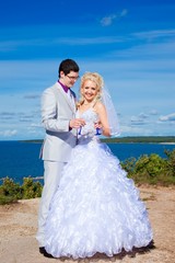 Fototapeta na wymiar happy groom and bride on a sea coast