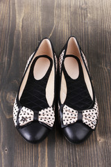 Female flat ballet shoes patterned with black polka dots