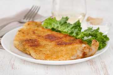 fried turkey with salad on the white plate