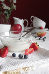 Gedeckter Frühstückstisch mit Joghurt und Früchten