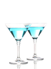 Blue cocktail in martini glasses isolated on white