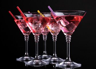 Red cocktail in martini glasses isolated on black